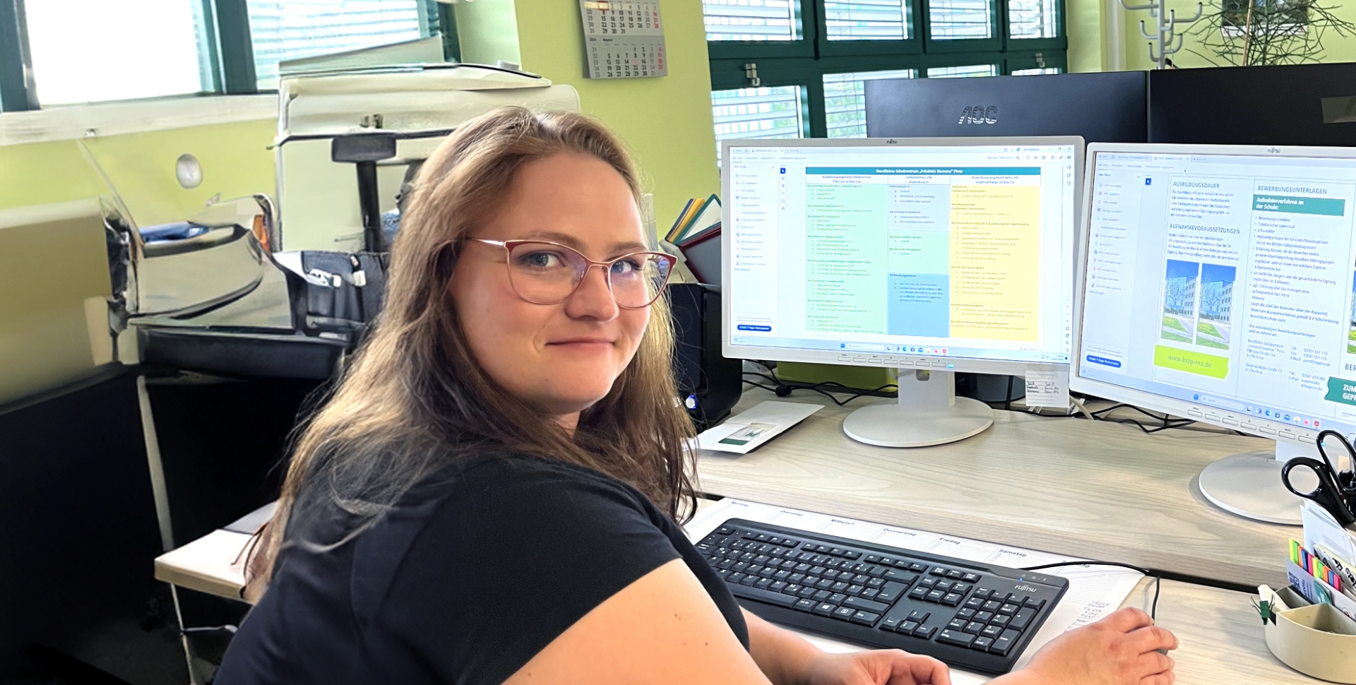 Diana Heimann, Schulassistentin in Qualifizierung, ist an ihren Monitoren bei der Arbeit in der Schule zu sehen.