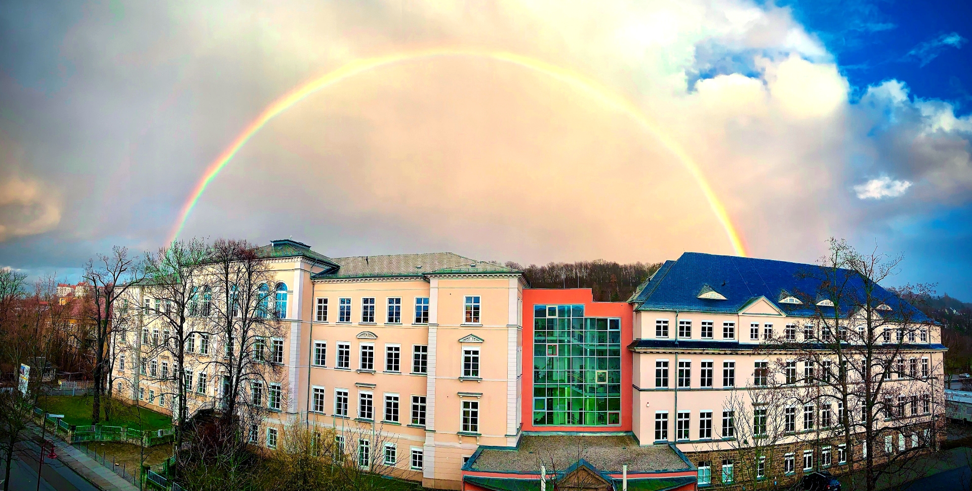 Über die Außenansicht des Friedrich-Schiller-Gymnasiums wölbt sich ein Regenbogen