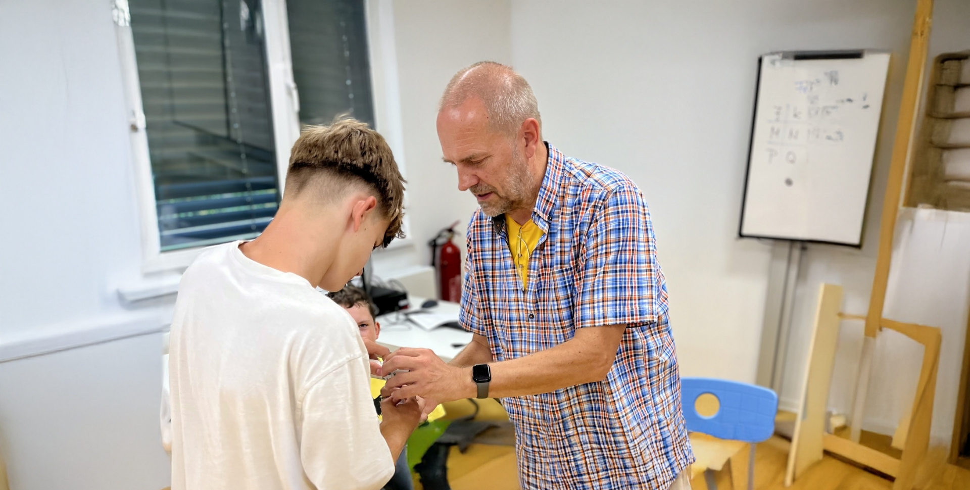 Lehrer Thomas Knapp ist in einer Erklärsituation mit einem seiner Schüler im Informatikunterricht zu sehen.