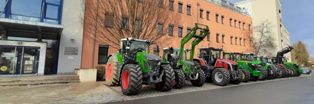 Eine Reihe Traktoren steht vor dem BSZ für Technik August Horch in Zwickau aufgereiht.