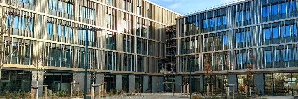 Übereck-Ansicht der holzverkleideten Fenster-Fassade des BSZ Wirtschaft Franz Ludwig Gehe in Dresden