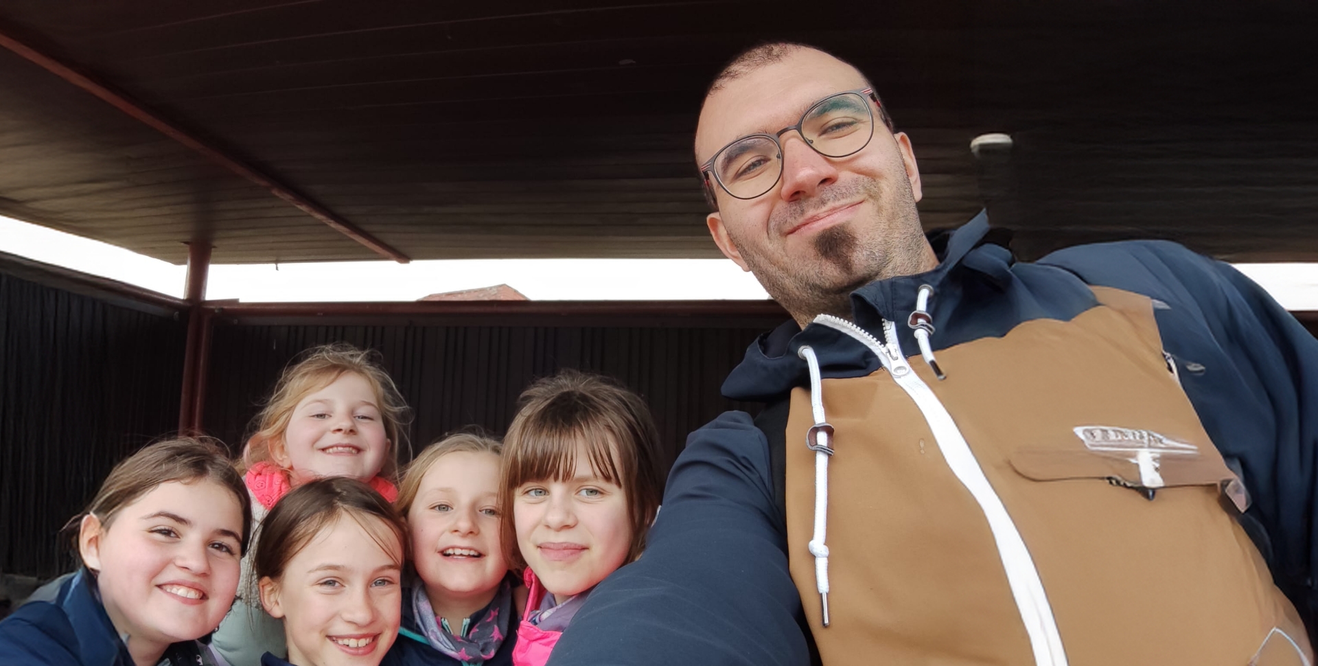 Ein Mann und fünf Schülerinnen links neben ihm sind untersichtig fotografiert.